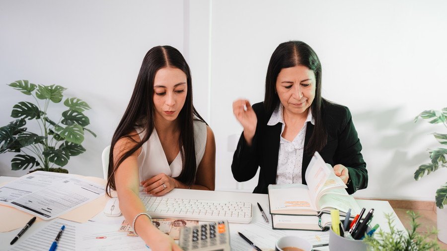 Dos contadoras de Espacio Contable revisando los papeles de trabajo de un cliente
