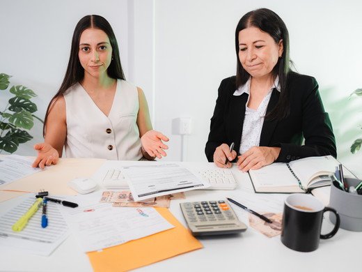 Dos contadoras revisando papeles de trabajo de un cliente